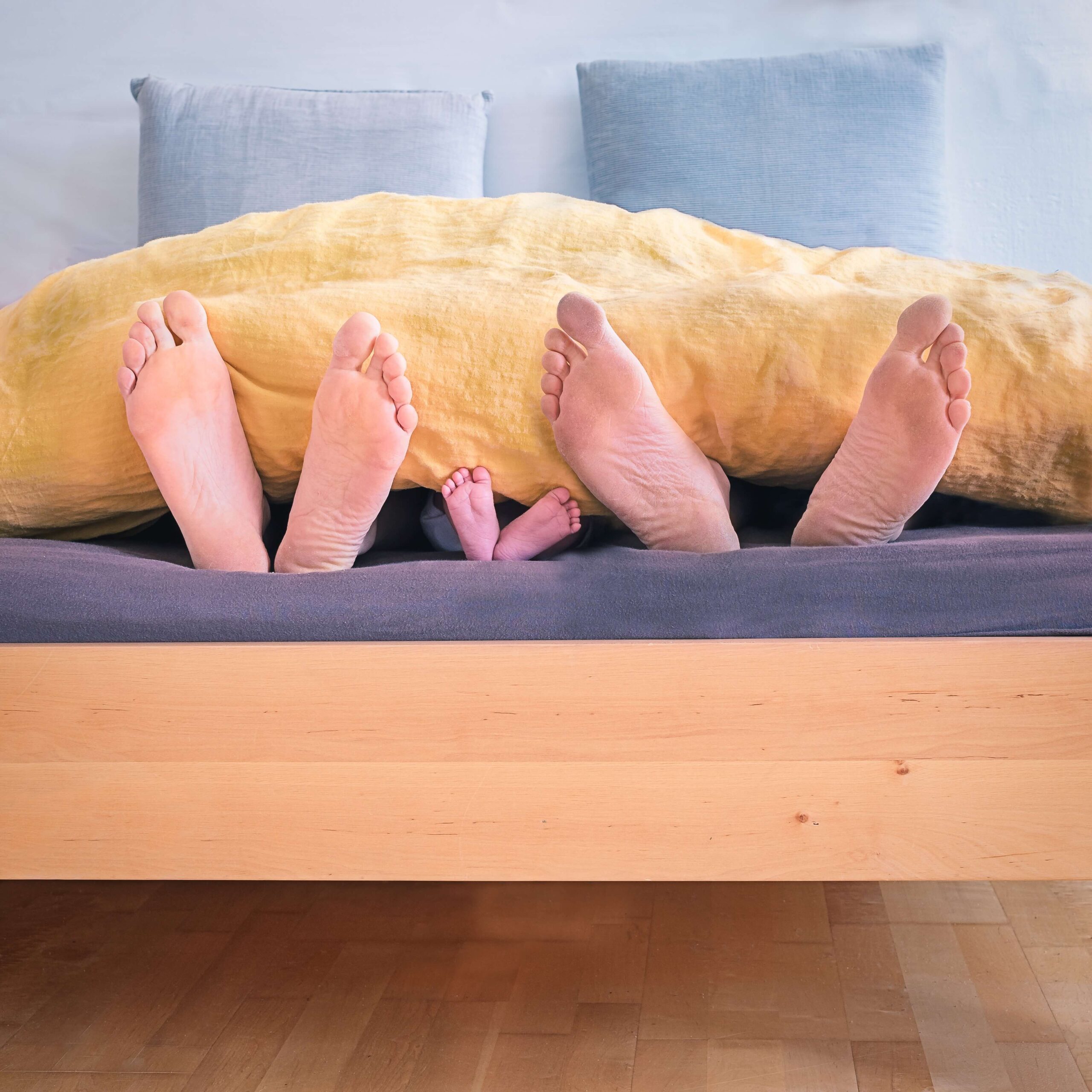 family lying on bed showing their foot